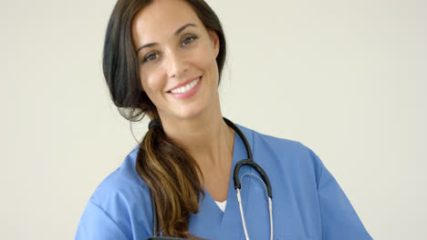 Woman-in-scrubs-holds-black-portfolio-and-smiles