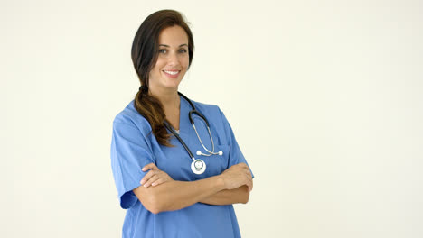 Woman-in-scrubs-crosses-arms-and-smiles-at-camera