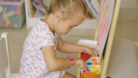 Cute-little-girl-mixing-paints-for-her-painting
