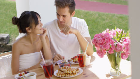 Couple-talking-at-breakfast-table-outside