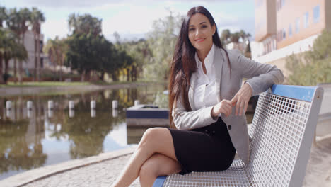 Gorgeous-business-woman-sitting-on-bench