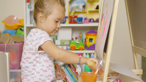 Little-girl-having-fun-painting-with-water-colors