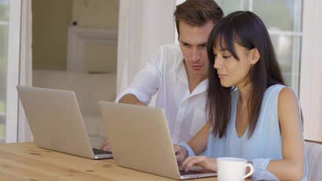 Man-and-woman-working-on-laptop-computers-together
