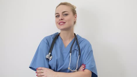 Female-doctor-in-blue-medical-coat-standing-isolated-with-arms-crossed--Looking-at-camera