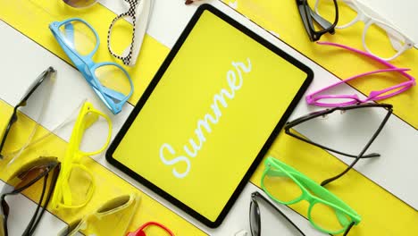 Various-style--shape-and-colour-sunglasses--Tablet-in-the-middle-with-text-SUMMER-