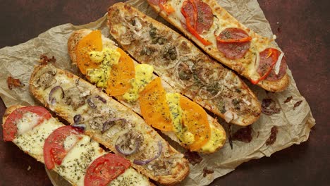 Composition-of-hot-tasty-baked-sandwiches-with-various-toppings--Cheese--tuna--mozarella--spices