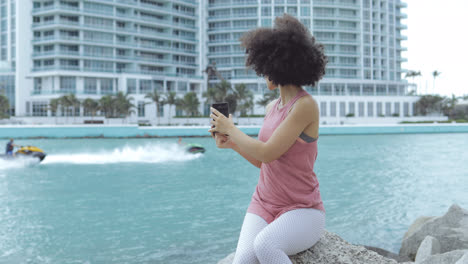 Casual-black-girl-taking-selfie-on-embankment