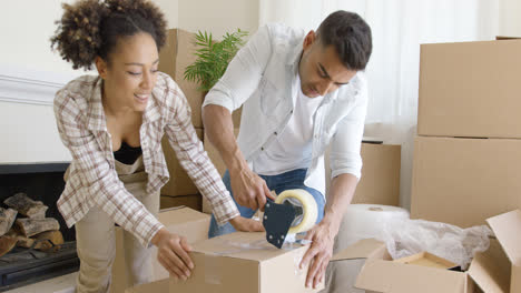 Couple-taping-boxes-as-they-pack-up-their-home
