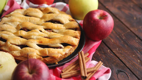 Homemade-pastry-apple-pie-with-bakery-products-on-dark-wooden-kitchen-table