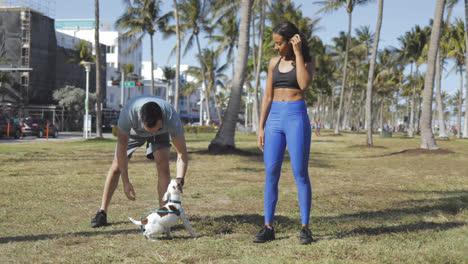 Sporty-couple-with-dog-in-park