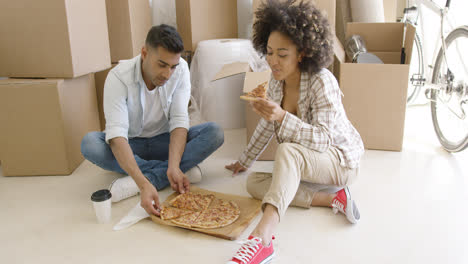Young-couple-tucking-into-a-pizza