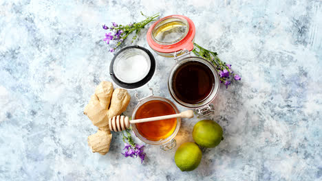 Healthy-food-table-with-different-kinds-of-honey--fresh-ginger-and-lime