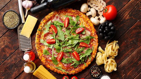 Italian-food-background-with-pizza--raw-pasta-and-vegetables-on-wooden-table