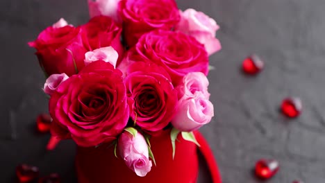 Pink-roses-bouquet-packed-in-red-box-and-placed-on-black-stone-background