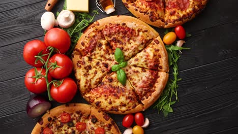 Freshly-served--three-various-pizzas-placed-among-tasty-ingredients--Top-view