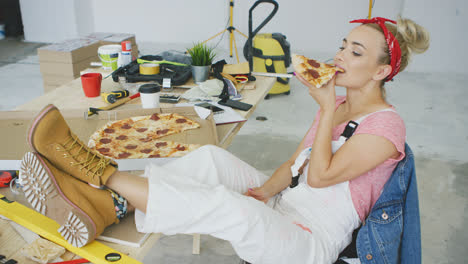Female-carpenter-eating-pizza-at-workplace