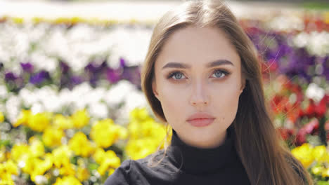 Schöne-Frau-Mit-Blauen-Augen-Und-Make-up-Posiert-Auf-Unscharfem-Hintergrund-Von-Bunten-Blumen