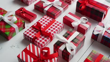 Side-view-of-wrapped-Christmas-presents-laid-on-the-wooden-table