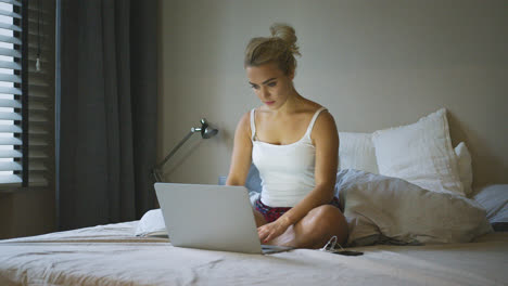 Charming-woman-using-laptop-on-bed