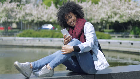 Cheerful-woman-with-smartphone-outside