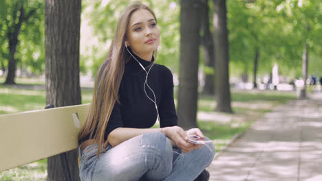 Pretty-female-with-smartphone-on-bench