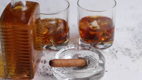 Bottle-and-glasses-of-brandy-or-wiskey-and-nice-big-cuban-cigar