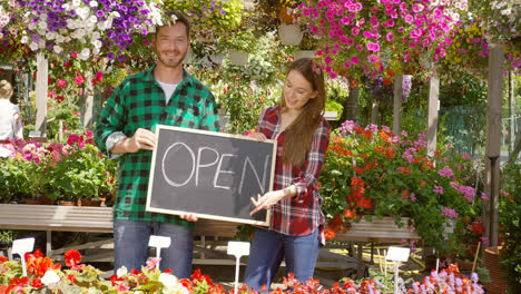 Two-florists-with-open-sign-in-their-shop