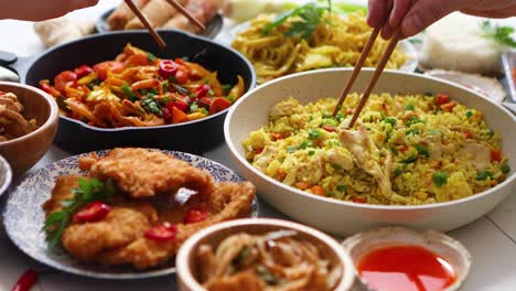 Family-meal-concept-with-asian-food-Plates-pans-and-bowls-full-of-tasty-oriental-dishes