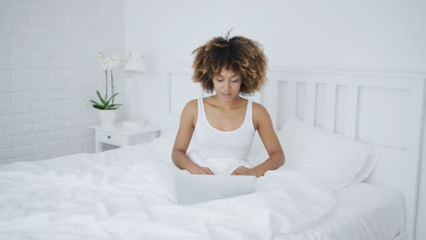 Charming-woman-with-laptop-in-bed