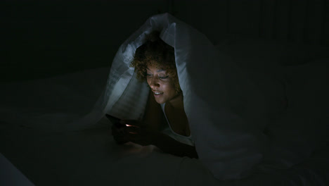 Young-woman-using-phone-in-dark-room