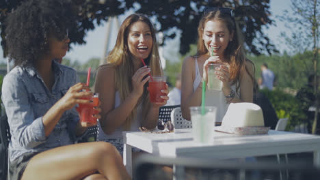 Stylish-young-girls-having-drinks-outside