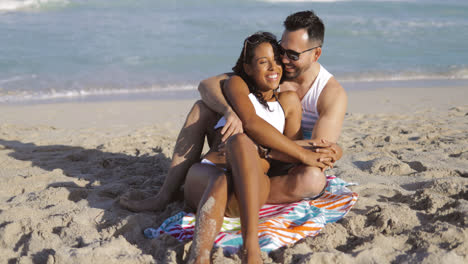 Cuddling-happy-couple-on-beach