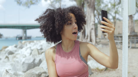 Young-girl-using-phone-for-selfie-on-riverside
