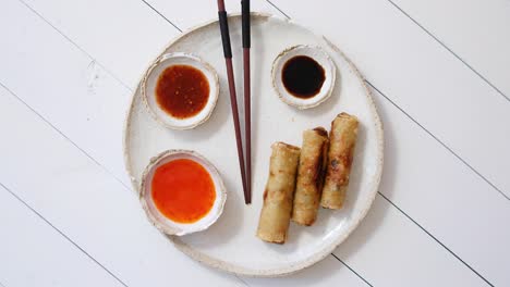 Fried-Chinese-Thai-or-Vietnamese-traditional-spring-rolls-or-nems-served-on-ceramic-plate