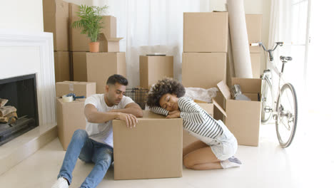 Tired-young-couple-relaxing-on-cardboard-boxes