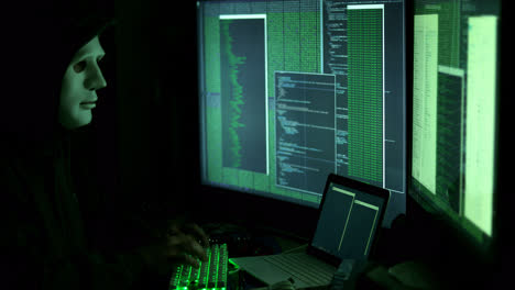 Anonymous-man-hacking-computers-in-dark-room