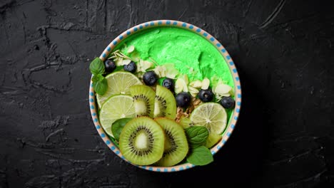 Green-smoothie-or-yogurt-bowl--With-fresh-kiwi--blueberries--lime-and-almond-flakes